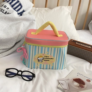 Macro view of blue striped dog makeup bag with pink lid and yellow handle on soft white linen