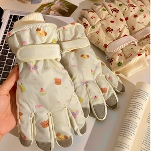 Detail of children's ski gloves with cartoon patterns and adjustable velcro wrist strap
