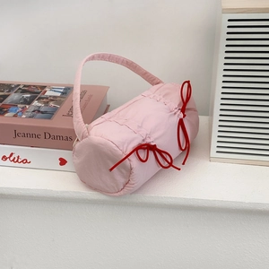 Detailed view of pink quilted barrel pencil case with red bow ties and carrying handle