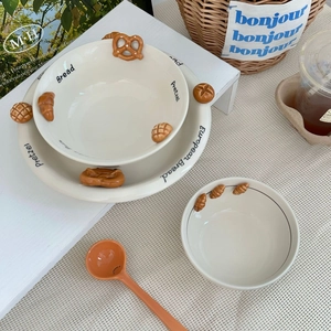 Detailed close-up of ceramic tableware with 3D relief croissants and pretzel motifs
