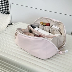 Interior detail of large pink cosmetic bag showing storage compartments and zipper pockets