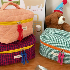 Quilted checkerboard cosmetic bags in orange and green with top handles and zippers