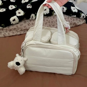 White quilted puffer travel bag with large capacity pockets and plush puppy charm