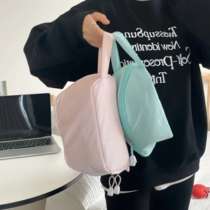 Minimalist nylon cosmetic travel bags in pink and mint green with top handles and zippers
