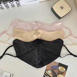 Flat lay of silk sun protection masks in pink, gold, and black with adjustable ear loops