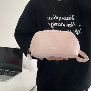 Handheld pale pink travel toiletry bag with zipper and jolly logo branding