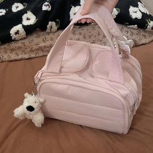 Pink quilted nylon travel bag with multiple zipper pockets and cute plush dog charm