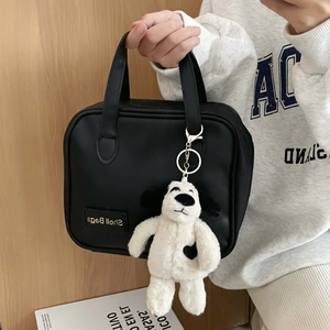 Black nylon tote bag featuring a cute plush dalmatian puppy keychain with heart spot