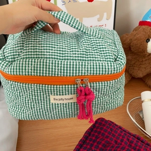 Detail of quilted green checkerboard cosmetic bag with soft padding and zip closure