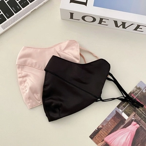 Close-up of silk sun protection masks with adjustable ear loops in pink and black