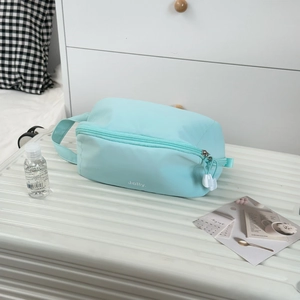 Detail view of the mint blue makeup bag featuring a durable zipper and top handle strap