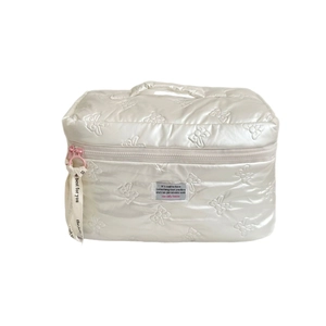 Quilted bow makeup bag in pearl white with elegant top handle and pink ribbon detail