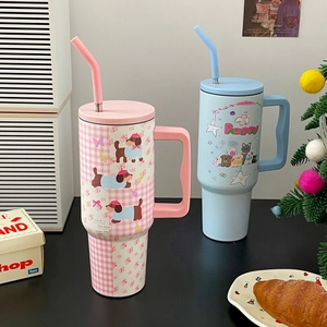 Detail of insulated tumblers with handle, straw, and cute cartoon puppy patterns