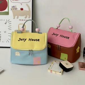 Detail of Jolly House house-shaped makeup bags with cute contrasting colors and bead handles