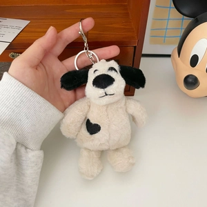 Close-up of soft plush puppy keychain featuring black long ears and heart patch detail