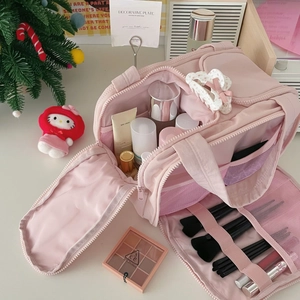Detailed view of pink multi-layer makeup bag with spacious compartments and brush slots