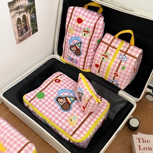Pink checkered travel luggage organizers with cute Rainbow Dog cartoon prints in a suitcase