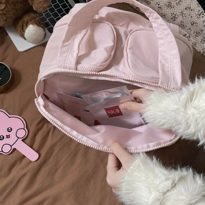 Detail of pink fabric makeup bag showing large capacity for storing facial masks