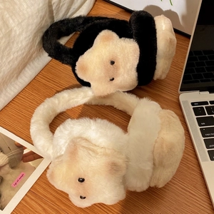 Dettaglio di paraorecchie in peluche a gatto con stelle ricamate su scrivania