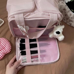 Pink minimalist cosmetic bag detail showing internal mesh pockets and multi-layer storage
