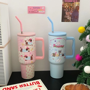 Detail of 40oz stainless steel tumblers with cute cartoon dog prints and ergonomic handles