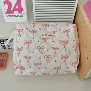 Close-up of floral quilted toiletry bag with pink bows and the jolly house label