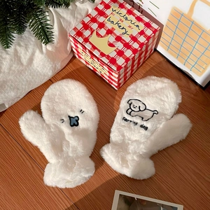 Détail de mitaines blanches en peluche avec broderie chien sur fond de maison douillet