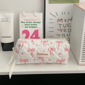 Detail of floral bow quilted makeup bag with zipper and comfortable carry handle