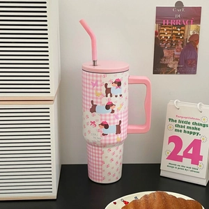 Detail of pink plaid insulated tumbler with dachshund graphics and a steady carry handle