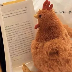 Peluche coq en fausse fourrure marron et rouge lisant un livre dans un décor chaleureux