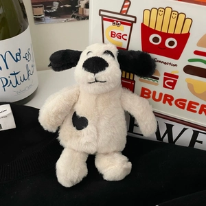 Detail of soft plush puppy toy with black heart spot on a cozy lifestyle background