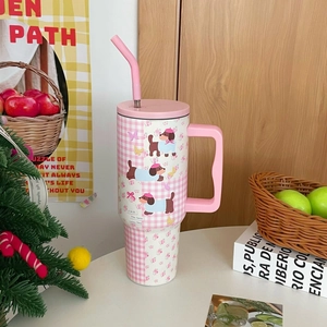 Detail of pink floral dog pattern on insulated stainless steel tumbler with straw and handle