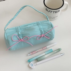 Detail of light blue quilted pencil case with pink bows and a portable handle strap