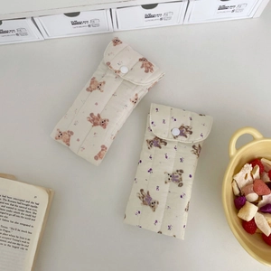 Detailed close-up of quilted cotton eyewear pouches featuring bear and floral prints