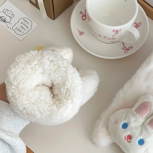 Detail of white plush rabbit mitten with soft texture and cute embroidered star details