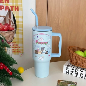 Detail view of light blue 40oz stainless steel tumbler with handle and puppy design