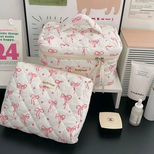 Detail of quilted two-piece makeup bag set with pink bows and floral patterns