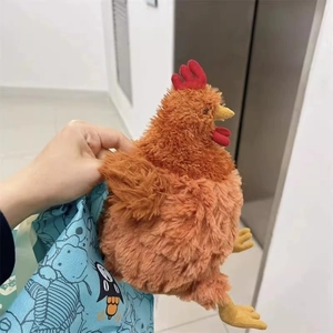 Gros plan du poussin en peluche marron duveteux avec une crête rouge et un bec jaune