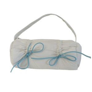 White puffer cylinder shoulder bag with light blue drawstring bows and quilted texture