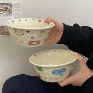 Detailed view of hand-held ceramic bowls with cute cartoon patterns and wavy texture