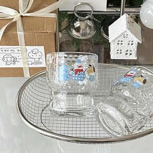 Two Christmas snowman glass cups with gift box in a festive holiday scene setup