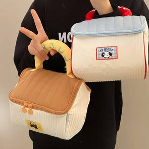 Close-up of quilted fabric makeup bags with cute puppy patches and lucky handle details