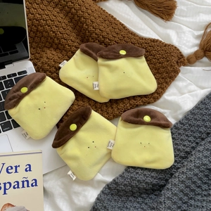 Five pieces of cute plush caramel pudding pouches scattered on cozy bedding decor