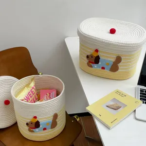 Detailed view of yellow striped woven cotton rope baskets with cute dog patch and pom pom lid