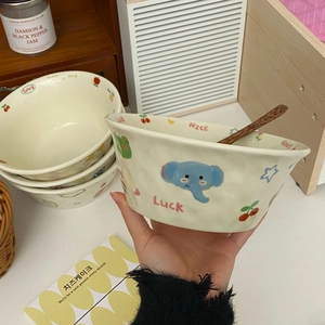 Close-up of cute ceramic bowl with cartoon graffiti and wooden spoon in a cozy setting