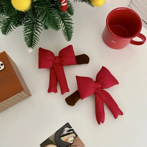 Detail of red bow door handle covers with plush trim in a cozy Christmas setting