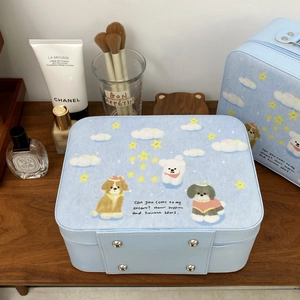Detail view of sky blue puppy makeup case with protective metal feet on a wooden shelf