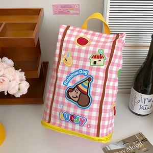 Detail of pink plaid storage bag featuring a cartoon dog and yellow carry handle