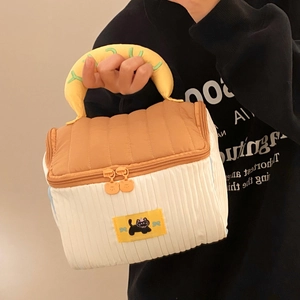 Detail of cute house makeup bag showing double-ended orange zippers and cartoon bear pullers