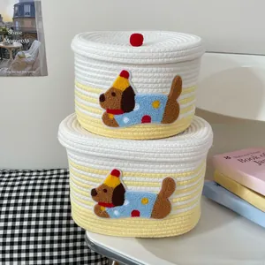 Close-up of woven cotton rope storage baskets with cute puppy patchwork and red pom pom lid